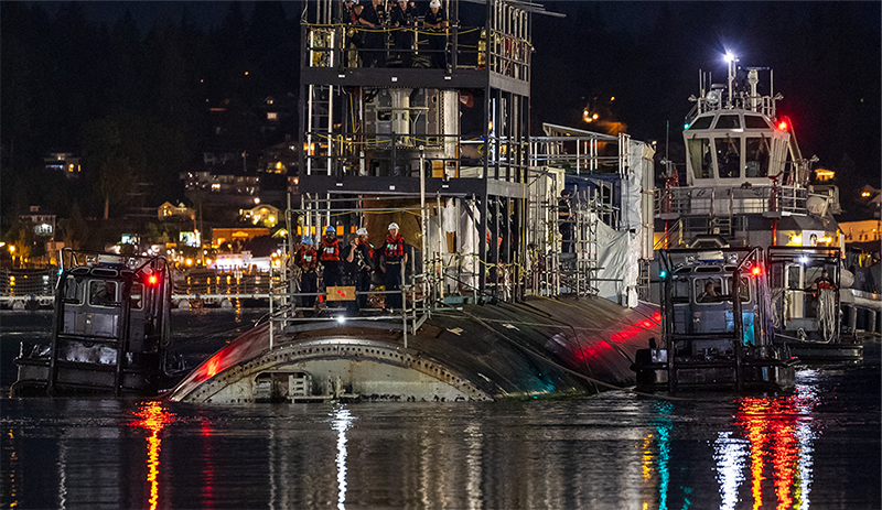 Workers in hard hats working on a submarine.