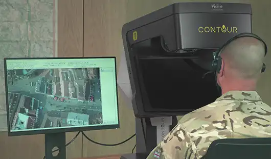 Man in camouflage looking into stereoscopic viewing equipment