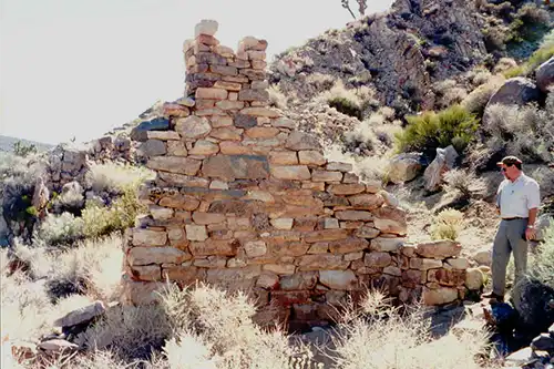 Person standing by ruins at an archiological site